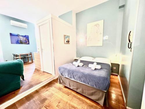 een slaapkamer met een bed en een groene stoel bij ApartHotel Riviera - Grimaldi Coeur de Ville - Large Studio AC with bigger South Terrace - Hyper Centre - 5mn plage- TERRASSE ESPRIT in Nice