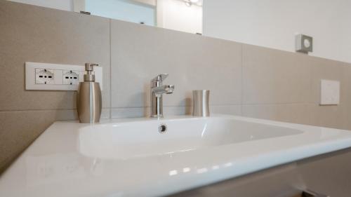 lavabo blanco en el baño con espejo en Villa Monte Bianco, en Mandello del Lario