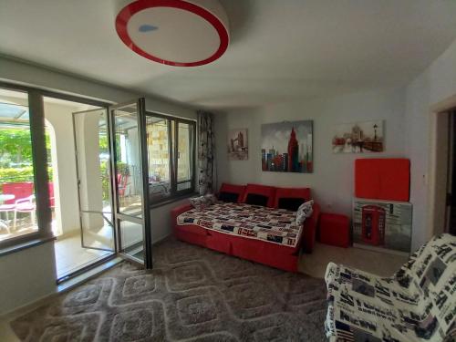 um quarto com uma cama vermelha e uma janela em Luxury Apartments Artur em Sveti Vlas