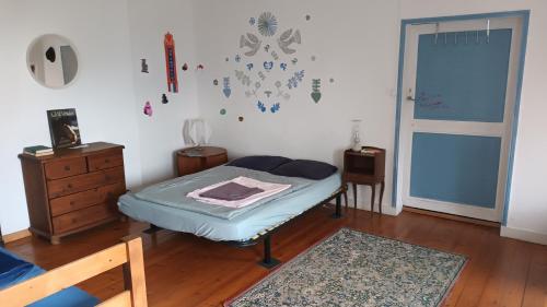 um quarto com uma cama, uma cómoda e uma porta em GUEST HOUSE groupe et Famille em Saint-Paimboeuf