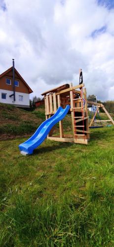 a playground with a blue slide in a field at Chata Štíty in Štíty