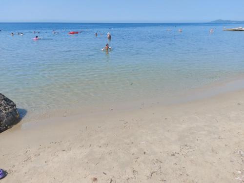 a group of people in the water at a beach at PANSION ALEXANDROS BY THE SEA in Nea Skioni