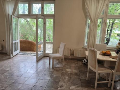 uma sala de jantar com mesa, cadeiras e janelas em Italian Villa em Turbaţi