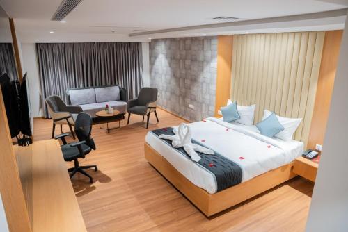 una camera d'albergo con letto e soggiorno di Hotel Tulips Grand a Hyderabad
