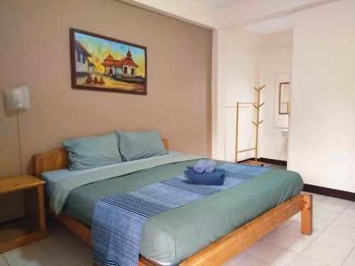 a bedroom with a bed with a blue blanket at The Shire Guesthouse in Chiang Mai