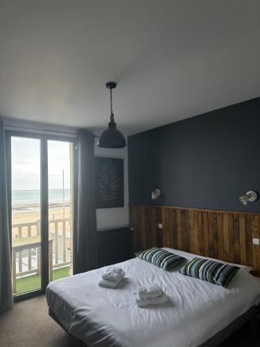 1 dormitorio con 1 cama y vistas a la playa en Papagayo, en Saint-Aubin-sur-Mer