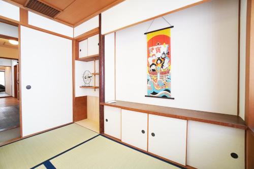 a room with white cabinets and a painting on the wall at Kagetsu 2nd Building in Osaka