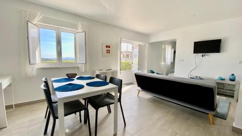 a dining room with a table and chairs and a tv at Casas de Campo - Real Mar in Ericeira