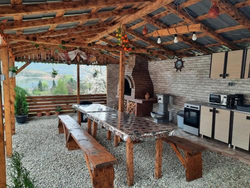 een patio met een houten tafel en een keuken bij Casa Claudiu in Eşelniţa