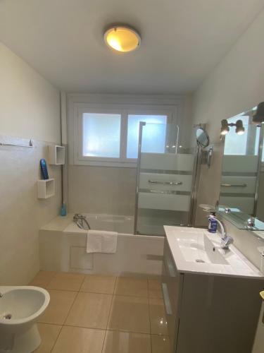 une salle de bain avec une baignoire, un lavabo et des toilettes dans l'établissement L'Albertini-Appartement élégant avec terrasse-Parking gratuit-, à Béziers