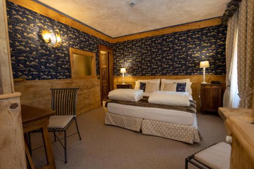 una camera con 2 letti in una stanza con carta da parati blu di Hotel Bucaneve a Breuil-Cervinia