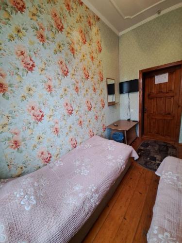 a bedroom with a bed and a floral wall at Zatyshok in Chernivtsi