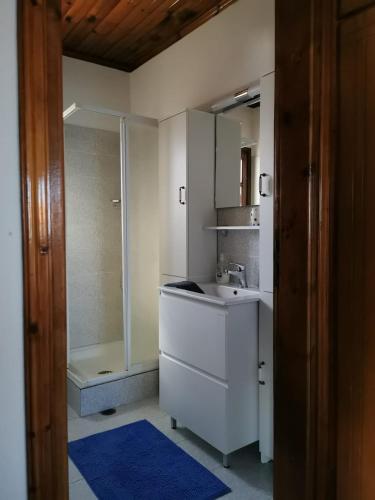 a white bathroom with a shower and a sink at Villa Christina in Karfas