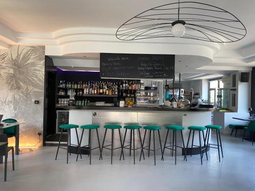 a bar with green stools in a restaurant at Hotel Aurora & Appartamenti in Nago-Torbole