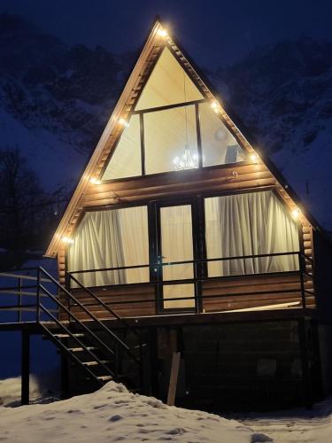 a house with lights on it in the snow at Rocky Views in Stepantsminda