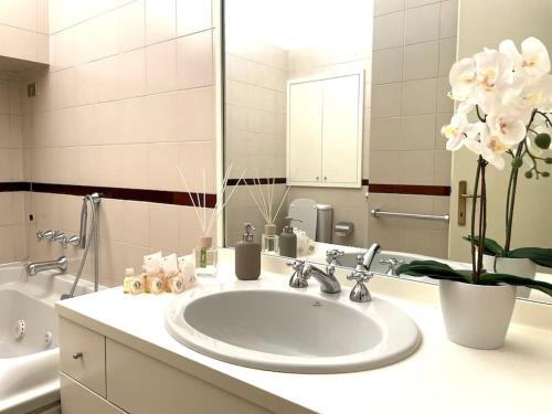bagno con lavandino e grande specchio di Tower Gombito's Apartment a Bergamo