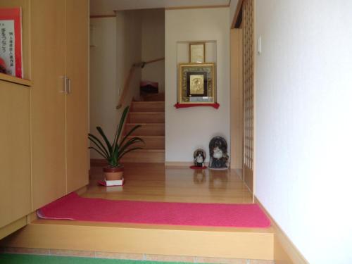 un corridoio con una pianta in vaso e una scala di ペンション石田 a Nii