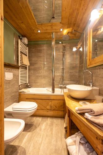 a bathroom with two sinks and a tub and a toilet at Hotel Bucaneve in Breuil-Cervinia