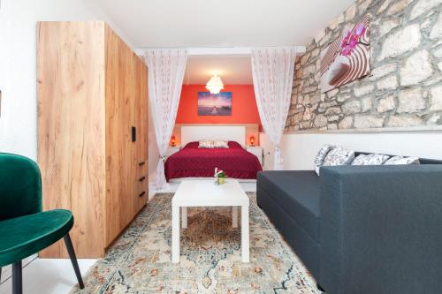 a living room with a couch and a bed at Studio Apartment Bisaku in Rovinj