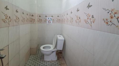 een badkamer met een toilet en vlinders aan de muur bij Reddoorz @ Homestay Gayatri in Malang