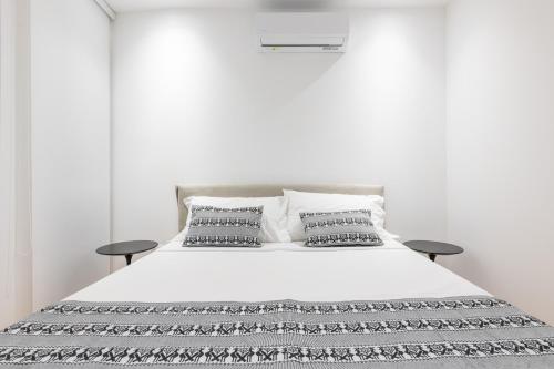 1 dormitorio con 1 cama blanca y 2 almohadas en A e C Homedesign Stampace, en Cagliari