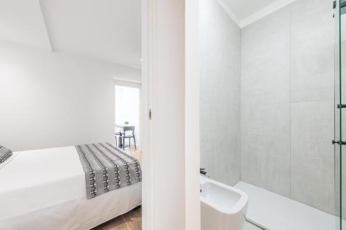 Baño blanco con cama y lavabo en A e C Homedesign Stampace, en Cagliari