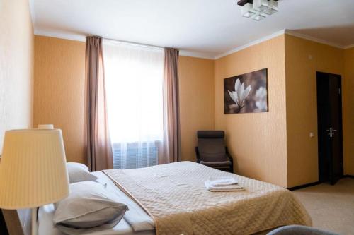 - une chambre avec un lit doté d'une lampe et d'une fenêtre dans l'établissement Comfort Hotel, à Aksay