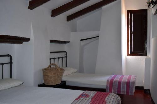 Habitación blanca con 2 camas y ventana en Gîte rural 100 % authentique (8 pers) avec piscine, en Los Arenales