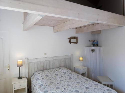 een slaapkamer met een bed en twee nachtkastjes bij Les Bois Flottés en Ré in Sainte-Marie-de-Ré