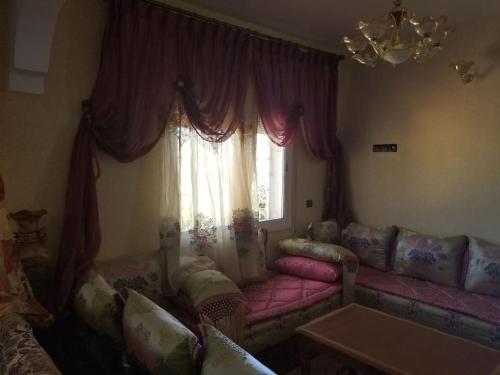 salon z różową kanapą i oknem w obiekcie PEACE LOVE AND CANNABIS 