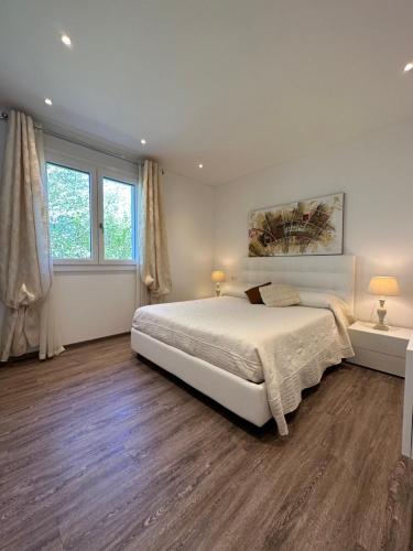 a bedroom with a large bed and two windows at Appartamento Campiano B in Malcesine