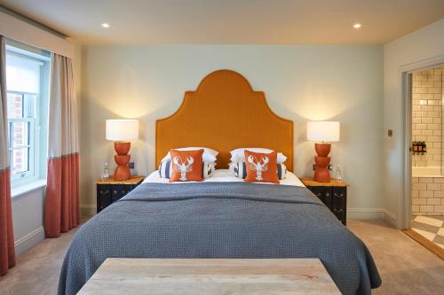 a bedroom with a large bed with orange pillows at Hotel Du Vin Poole in Poole