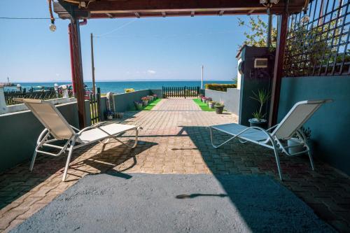 two chairs on a patio with the ocean in the background at Seashell Luxury Apartment in Nikiti