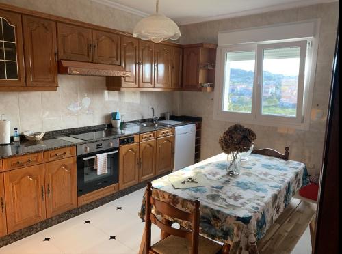 a kitchen with a table with a vase on it at Falda do Pedroso in Santiago de Compostela