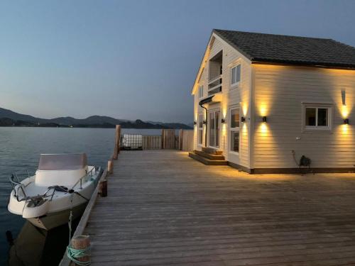 a boat parked on a dock next to a house at Torvholmen in Fosnavåg