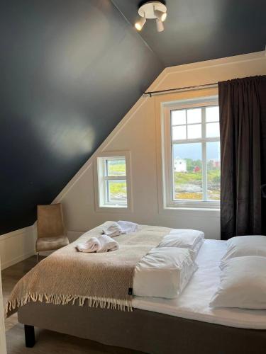 a bedroom with a bed and a window and a chair at Torvholmen in Fosnavåg