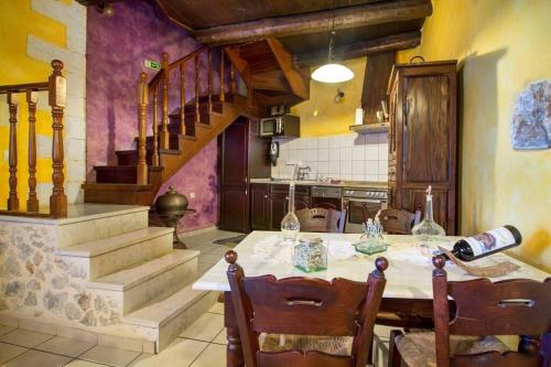 a kitchen with a table with chairs and a staircase at Samonas - 5 maisonettes with breathtaking views in Chania Town