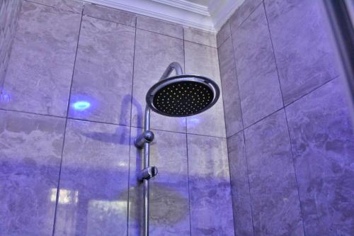 a shower with a shower head in a purple bathroom at Kojosvilla Ground floor in Kwedonu