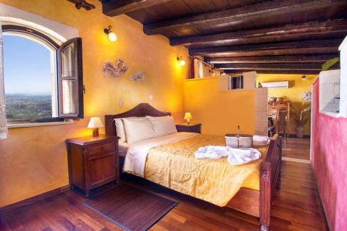 a bedroom with a bed in a room with a window at Samonas - 5 maisonettes with breathtaking views in Chania Town
