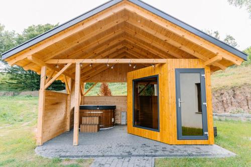 a wooden house with a large open door at DOMKI - Kaszuby Resort ZACISZE - new cottage in Chmielno