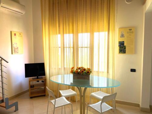una sala da pranzo con tavolo in vetro e sedie di Regina Beach Holiday Apartments a Tirrenia