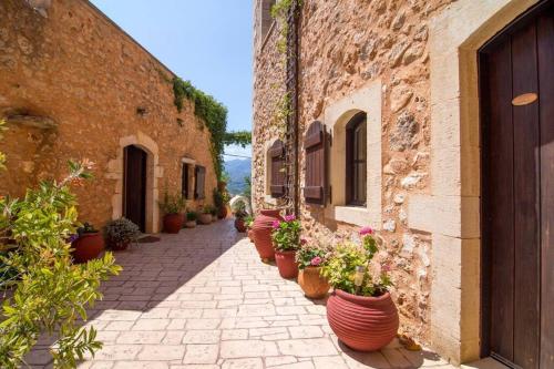 an alley with potted plants on the side of a building at Samonas - 5 maisonettes with breathtaking views in Chania Town