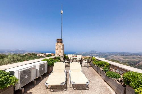 a balcony with a table and chairs and a lighthouse at Samonas - 5 maisonettes with breathtaking views in Chania Town