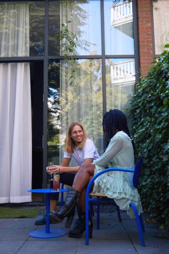 two women sitting on chairs in front of a window at Supernova Hotel in Rotterdam