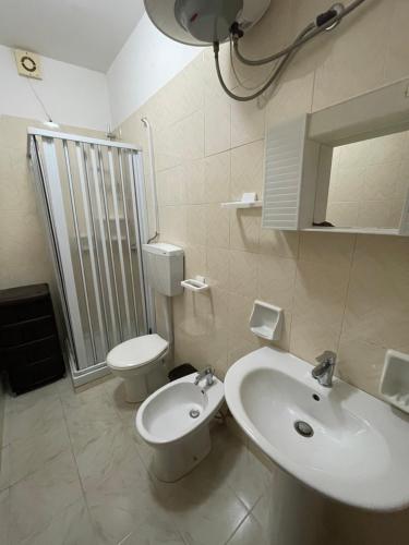 a white bathroom with a toilet and a sink at Appartamenti Bella Vista in Lampedusa