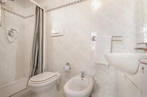 Baño blanco con aseo y lavamanos en Appartamento La Tavernetta, en Pian di Scò