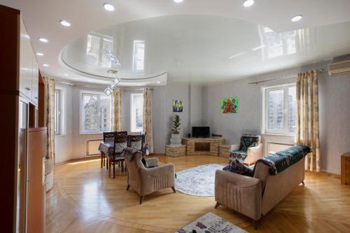 a living room with a couch and a dining room at Leyla Apartments 1 in Baku