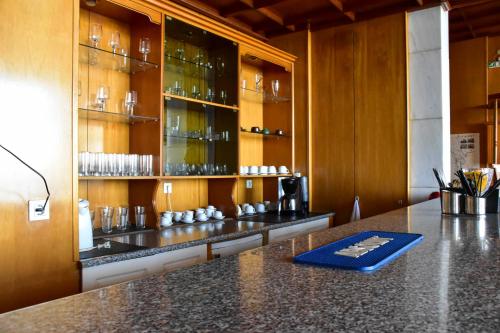 eine Küche mit einer Theke mit Gläsern auf den Regalen in der Unterkunft Leonidas Hotel in Gythio