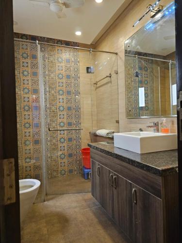 a bathroom with a sink and a shower and a toilet at Hostmystay- 3Bhk Terrace! Gk1 M block in New Delhi