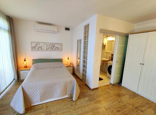 1 dormitorio con cama blanca y baño en LA VITA APARTMAN, en Balatonfüred